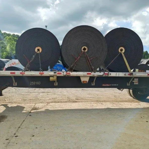 Flatbed carrying large rolls secured with straps